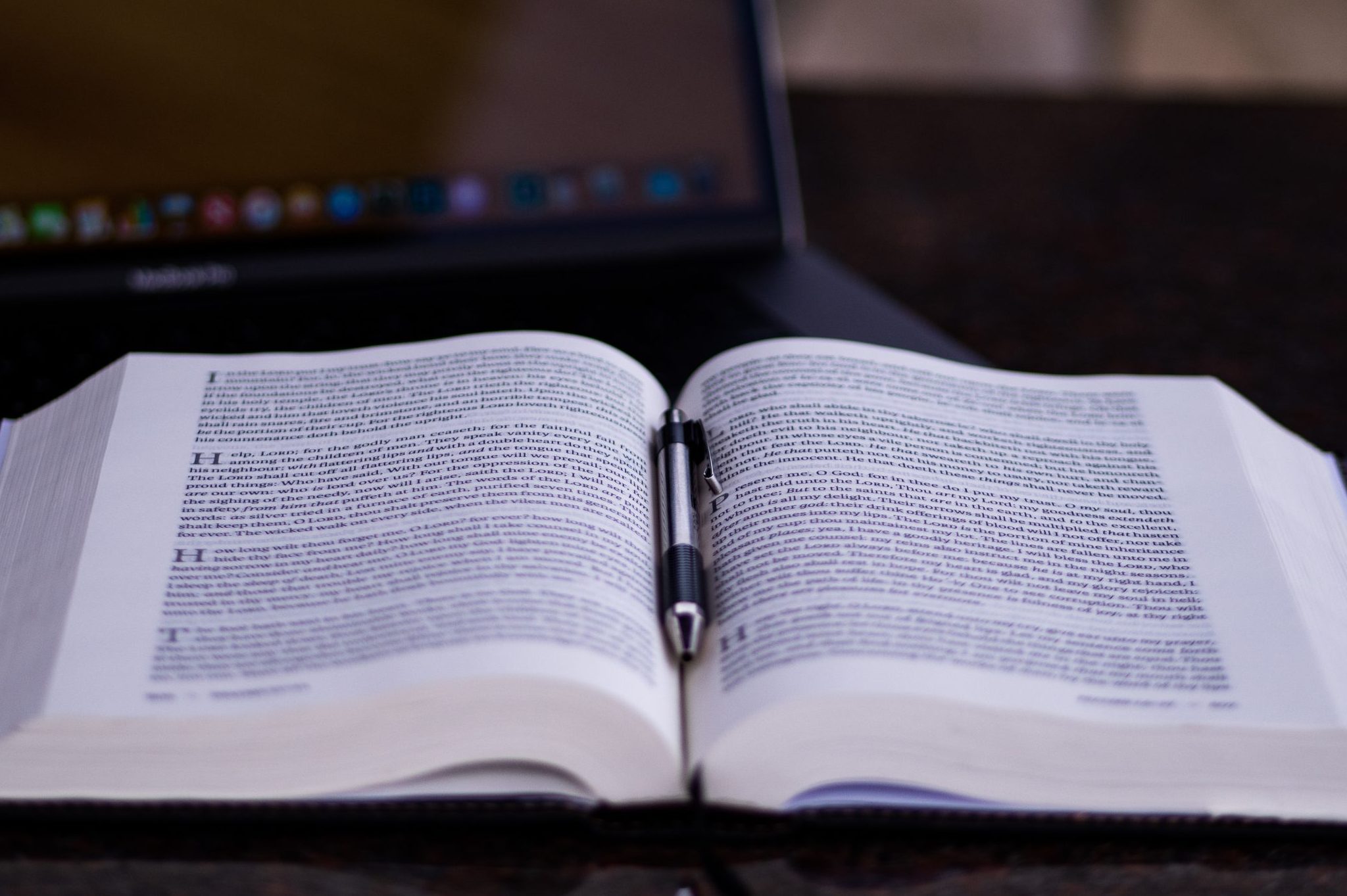 Open Bible with a pen sitting in the crease.