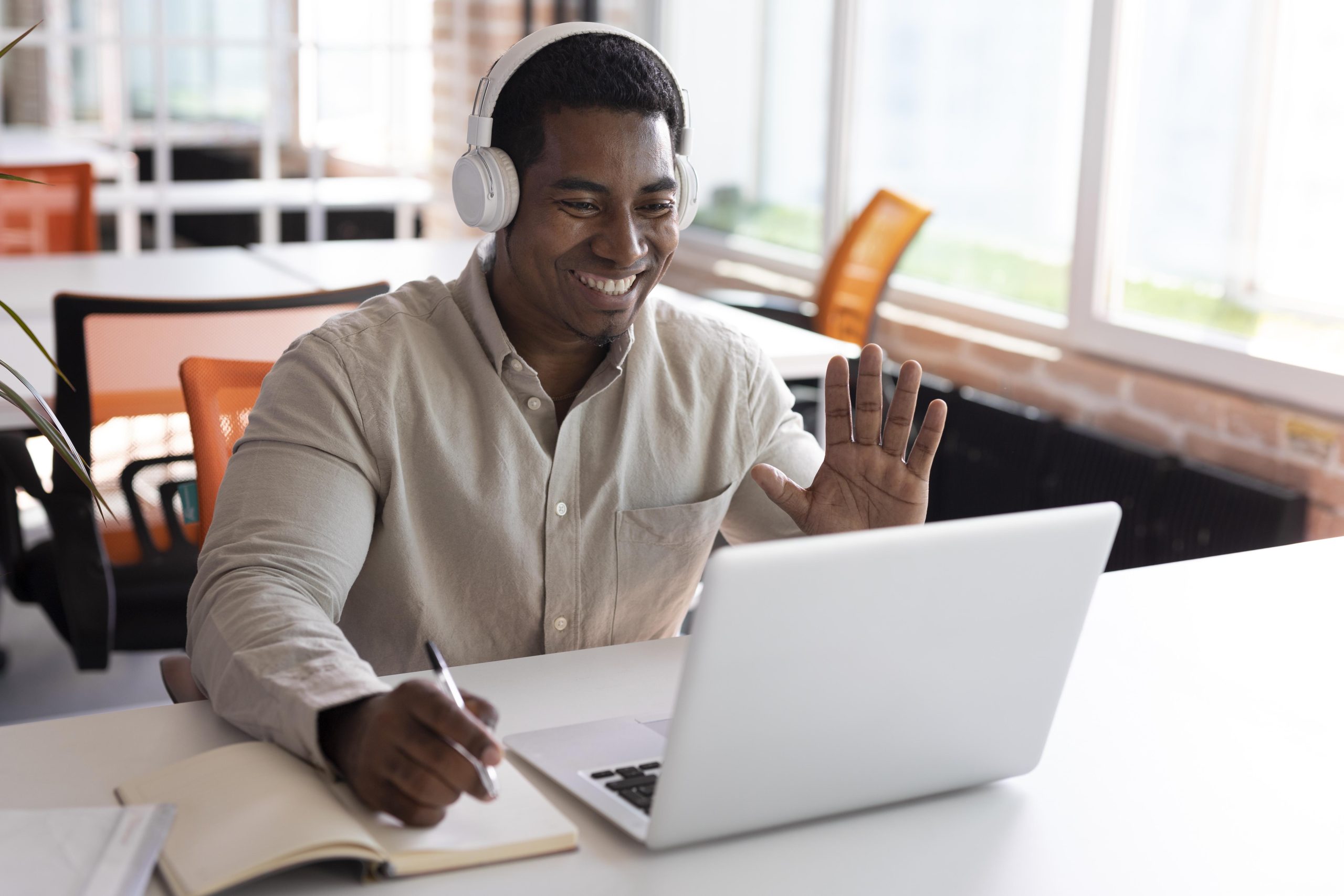 Man on laptop waving.